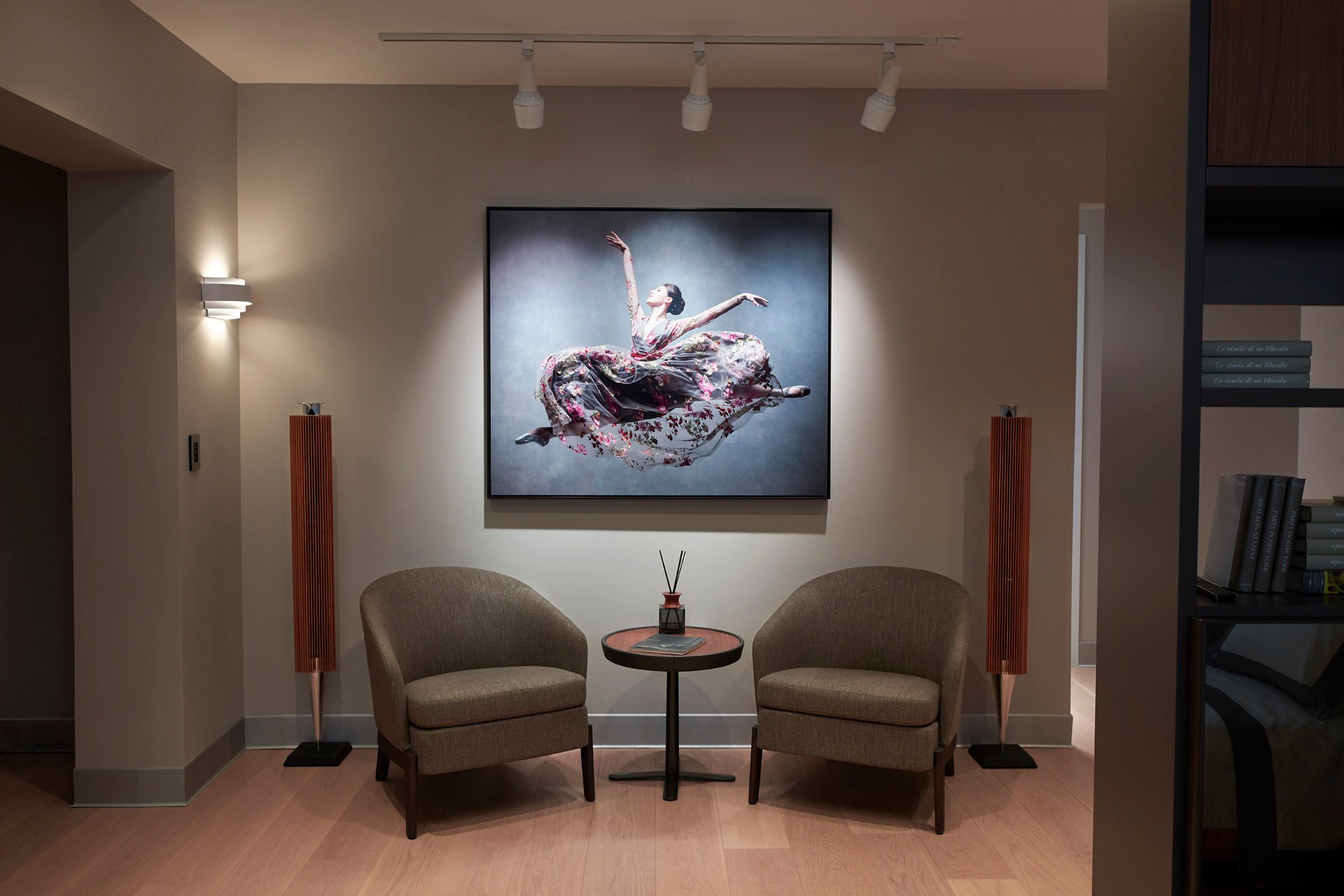SoWa showroom: listening chairs between two wood-finished speakers beneath a dancer photograph